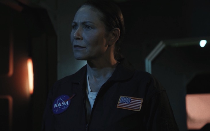 Marie Finch portraying Captain Terry in a dark NASA flight suit