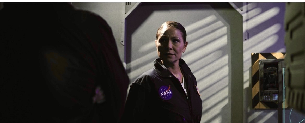 Marie Finch performing in a NASA uniform in a dramatic scene