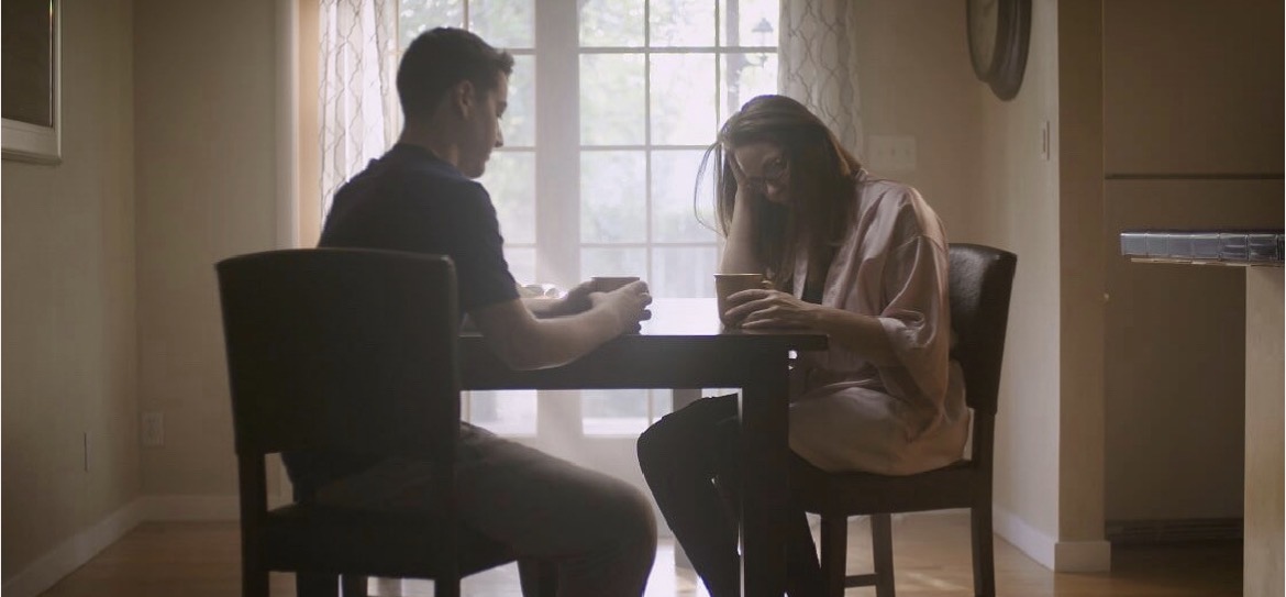 Marie Finch performing an intimate dramatic scene across a kitchen table